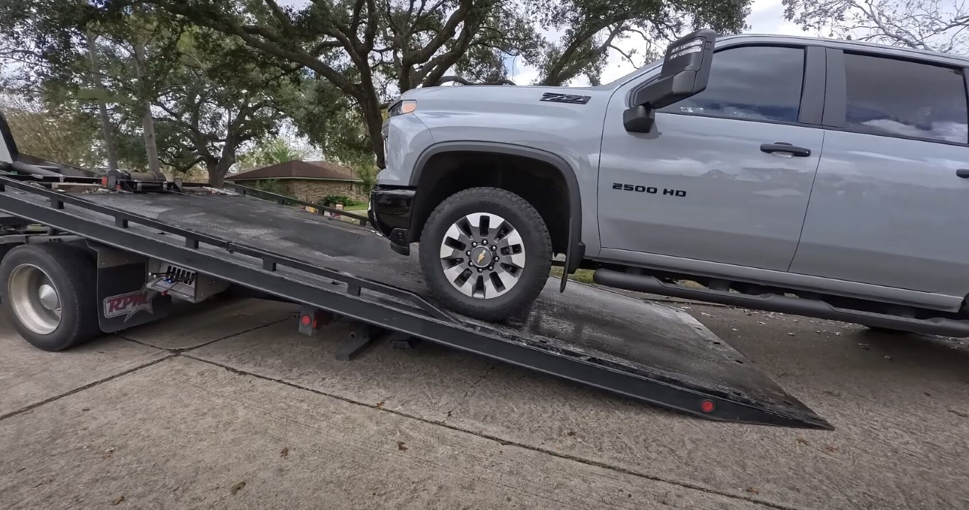 Professional heavy-duty tow truck safely transporting a large pickup truck in Pembroke Pines, FL