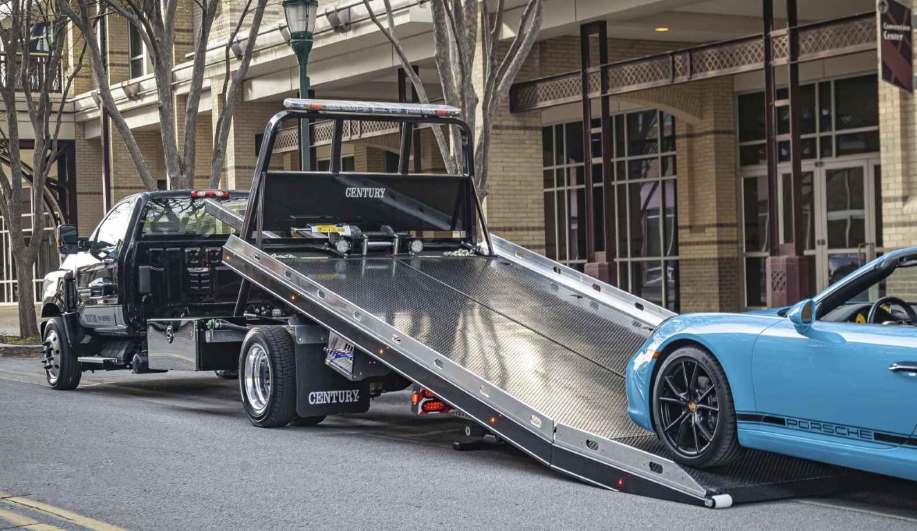Professional flatbed tow truck safely transporting a luxury car in Pembroke Pines, FL